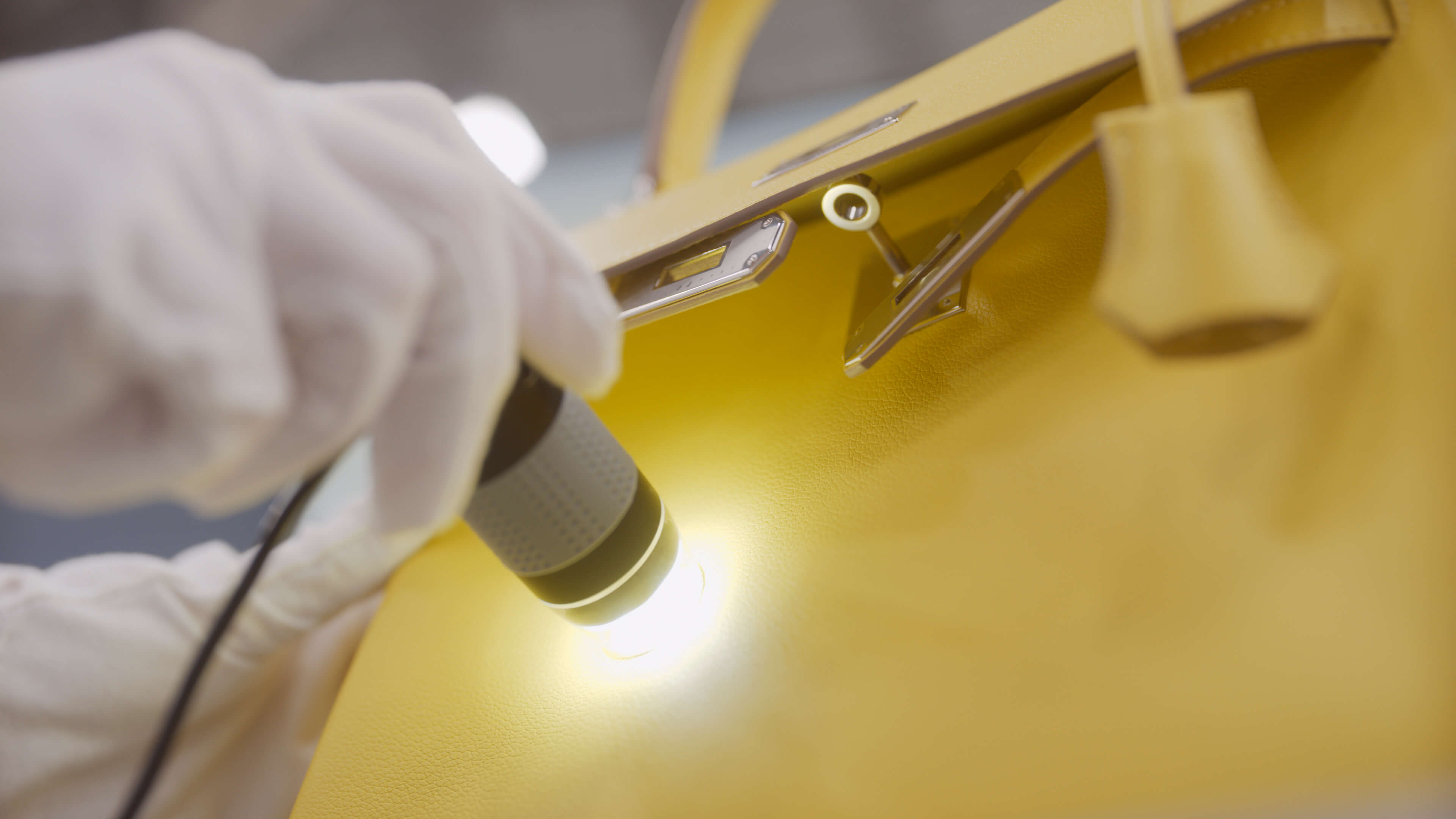 Specialist examining a luxury item to verify authenticity